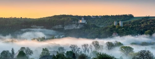 Landscape with the castle ruins Rudelsburg and Saaleck and manor Kreipitzsch, sunrise, morning fog
