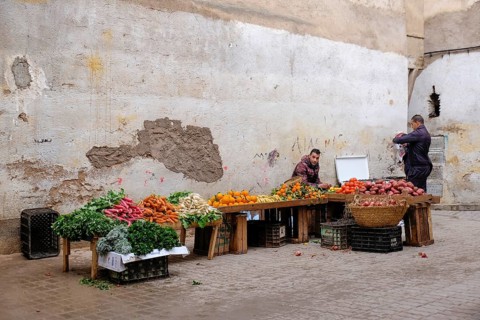 Two men selling vegetables in front of an old, plastered wall at a market, Fez, Morocco, Africa