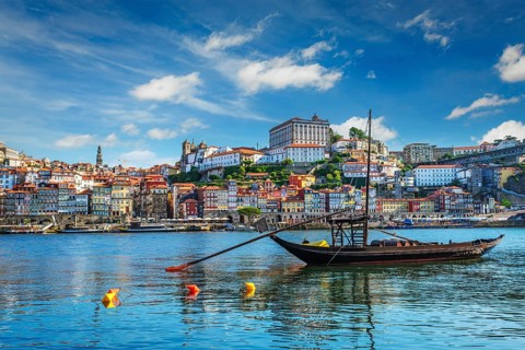 View of Porto city and Douro river with traditional boats with port wine barrels ship from famous