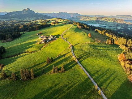 Mountain range near village Wertach, view to mt. Gruenten, sunrise, fog in valley, traditional