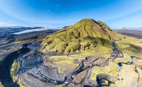 River along road F232 Öldufellsleid, slopes of Mt. Öldufell, moss-covered hill in black lava sand,