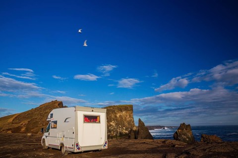 Motorhome parking on the shoreline, south of Sandvik with crashing waves. Rough nature