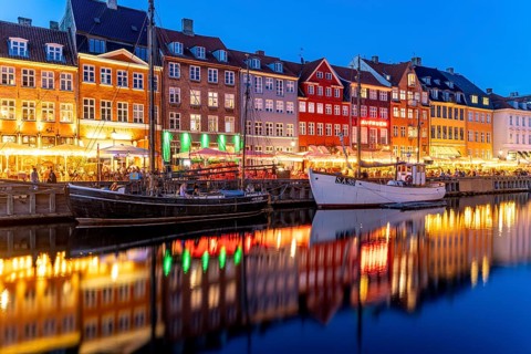 Colourful houses, restaurants and historic ships on the Nyhavn canal and harbour at dusk,