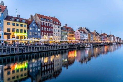 Colourful houses, restaurants and historic ships on the Nyhavn canal and harbour at dusk,