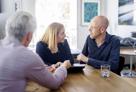 Symbolic photo on the subject of counselling. A young woman and a young man sit together at a table
