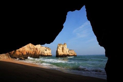 Praia do Pinhao, Lagos, Algarve, Portugal, A view from a grotto to the sea with a sandy beach and