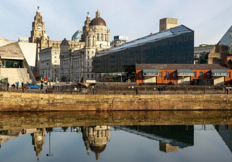 The Three Graces iconic waterfront landmark buildings reflected in water, Canning Dock, Liverpool,