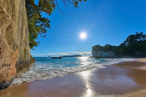 Sunlight on the horizon of a rocky beach, Cathedral Cove, Coromandel, Canterbury, North Island, New