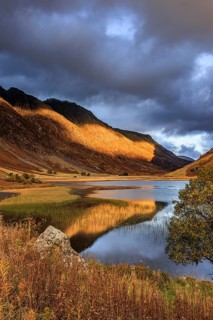 Mountains reflected in lake, evening light, cloudy mood, autumn, Loch Achtriochtan, Glencoe,