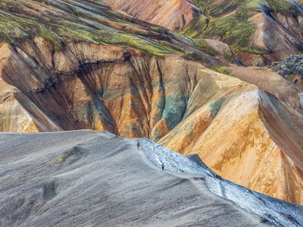 Hikers decending the slopes of Mt. Blahnukur, colorful rhyolite mountains, lava field,
