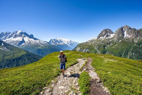 Mountaineer on hiking trail, mountain panorama with glaciated mountain peaks, Aiguille Verte with