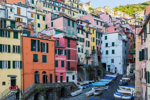 Colourful residential buildings and fishing boats parked in opened space between buildings in