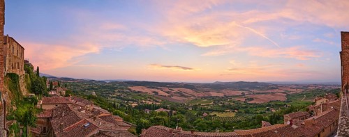 View from Montepulciano into a typical Tuscan landscape in Val d'Orcia with hills, trees, fields,