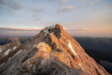 Rocky mountain ridge, summit of the Zugspitze with Zugspitze railway, Jubiläumsgrat, at sunrise,