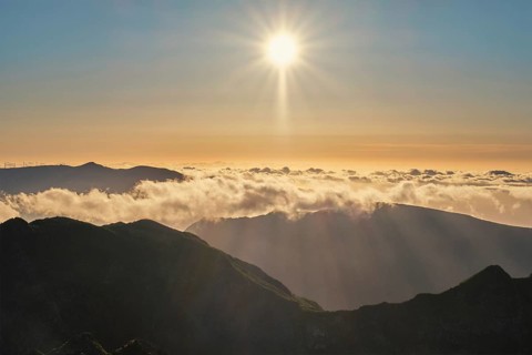 Aerial drone view of mountains over clouds near Pico Ruivo on sunset. Madeira island, Portugal,