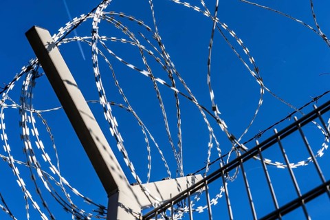 Symbolic image security, S-wire rolls, NATO wire, on a fence top, demarcation of a property,