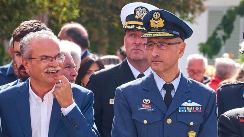 Man in military uniform at an outdoor event, next to him a laughing man, visit of Federal President