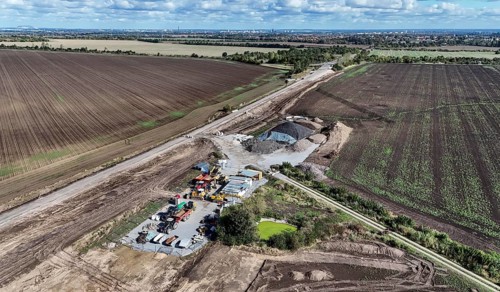 Construction vehicles are parked at an access road under construction to the High Tech Park at the