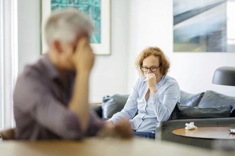 Symbolic photo on the subject of problems in a partnership. An older woman and an older man sitting