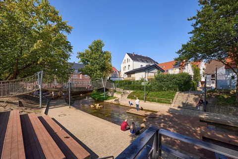 River Salze with suspension bridge for pedestrians and buildings at the Salzhof in Bad Salzuflen,