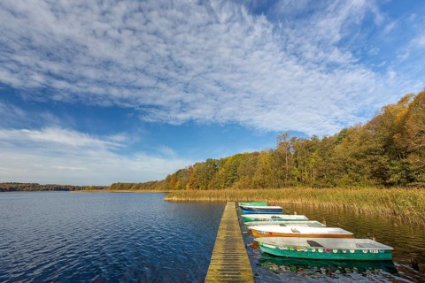 Wooden jetty with rowing boats at lake Schaalsee in autumn, fall, Biosphärenreservat Schaalsee,