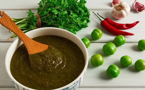 Tkemali sauce, traditional Georgian cuisine, green cherry plum, with ingredients for sauce,