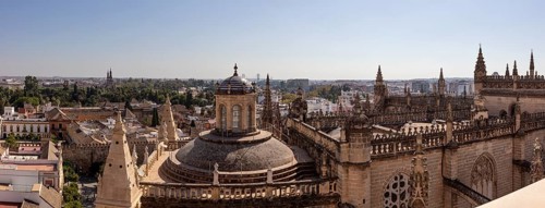 Gothic cathedral with dome in the middle of a historic cityscape, Seville