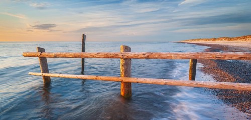 Fence on the beach of the Baltic Sea as the border of the cordoned-off core zone of the Western