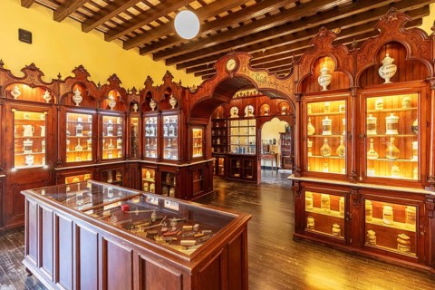 Traditional pharmacy interior with illuminated glass cabinets and woodwork, Jerez