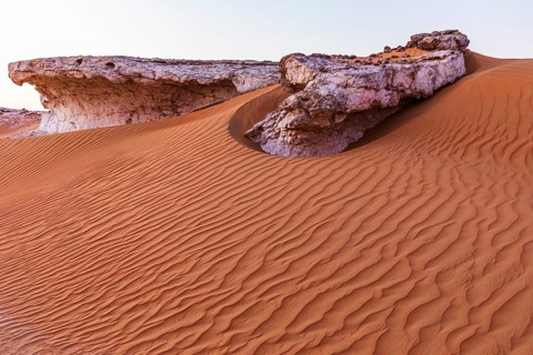 Striking cliffs surrounded by windswept sand structures, Huqf stone desert, Arabian Peninsula,