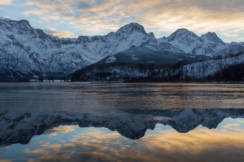 Lake Almsee in winter. Snow on the mountains and some clouds in the sky