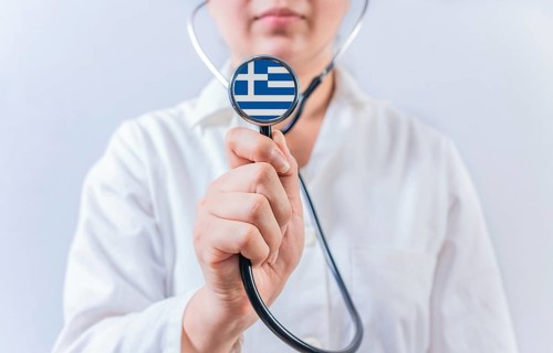 Doctor holding stethoscope with Greece flag. National Health System of Greece
