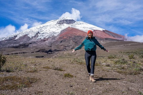 Women poses in front of the Cotopaxi volcano, Cotopaxi, Cotopaxi National Park, Latacunga, Ecuador,