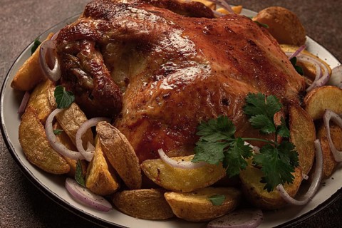 Fried, baked chicken, in the oven, with spices, and rustic potatoes, top view, homemade