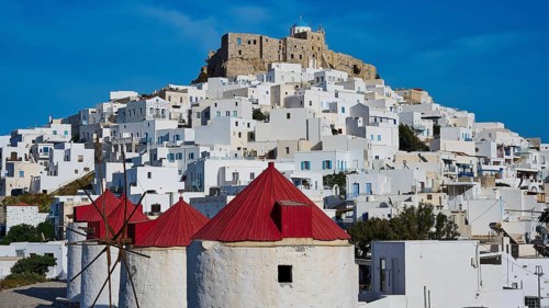 Castle and windmills above white houses under a sunny sky, Querini Castle, Chora, Astypalea,