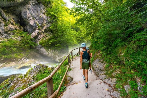 Tourists walking on a pathway along the radovna river in vintgar gorge, enjoying the scenic beauty
