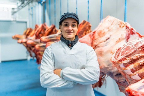 Portrait of a woman worker standing proud in the cold storage room of a meat factory