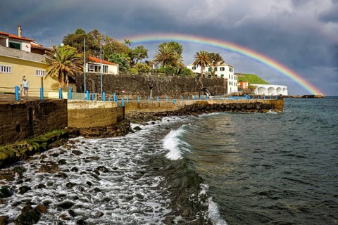 Promenade in rainy weather with rainbow on the beach of the Atlantic Ocean, municipality of Santa