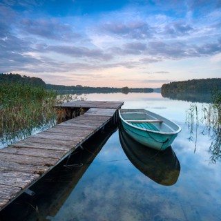 Morning atmosphere at the lake, wooden jetty with rowing boat in the reeds, Breiter Luzin,