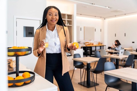Businesswoman enjoying a healthy breakfast with orange juice and fruits in a hotel restaurant