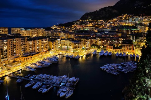Aerial view of Monaco Monte Carlo harbour and illuminated city skyline in the evening blue hour