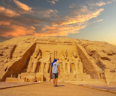 A young man walking towards the Abu Simbel Temple in southern Egypt in Nubia next to Lake Nasser.