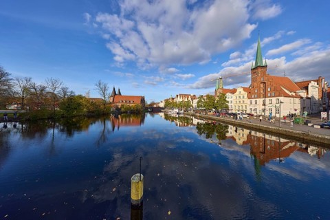 River Trave, quay wall, historic buildings, church towers of St. Marien and St. Petri, reflections