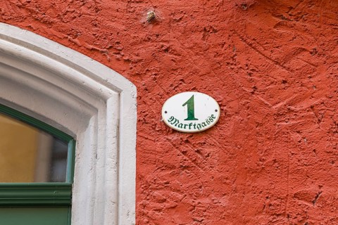 House number Marktgasse 1 on a red façade on the market square in Meißen, Saxony, Germany, Europe