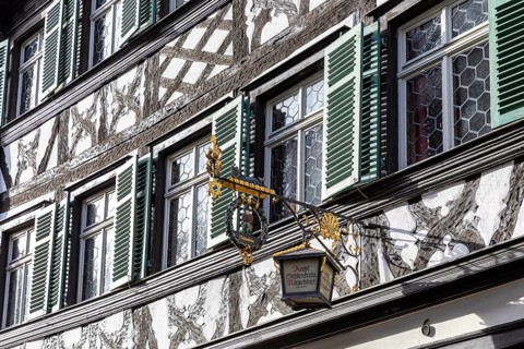 Façade with half-timbering and shutters and historic nose sign, famous Schlenkerla brewery,