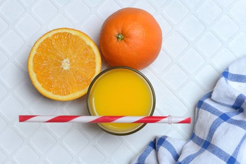 Orange juice in glass and orange, straw