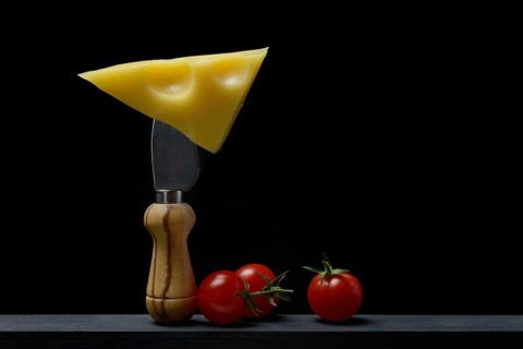 A piece of Swiss Emmental cheese on a cheese knife