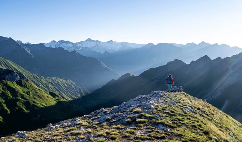 Hiker enjoying the mountain panorama in the morning, Venediger group, behind Dreiherrenkopf,