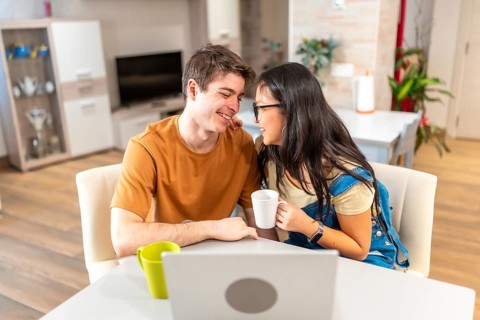 Young multi ethnic couple enjoying a quiet moment together at their home, sharing coffee and