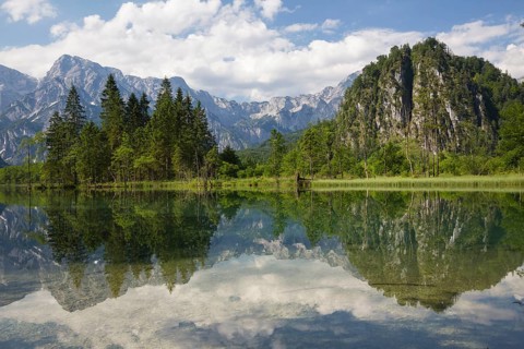 Lake Almsee in summer with totally smooth surface showing reflexion of the mountain Ameisstein
